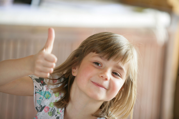 Young girl giving the thumb's up - Фото, изображение