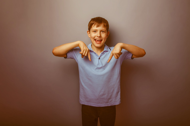 мальчик-подросток коричневый европейский внешний вид в синей футболке показывая t
 - Фото, изображение