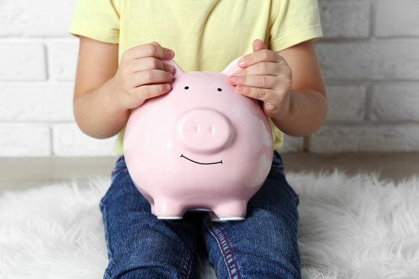 Little girl with the pig  moneybox - Foto, imagen
