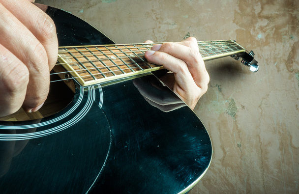 Closeup photo of an acoustic guitar played by a man. - Photo, Image