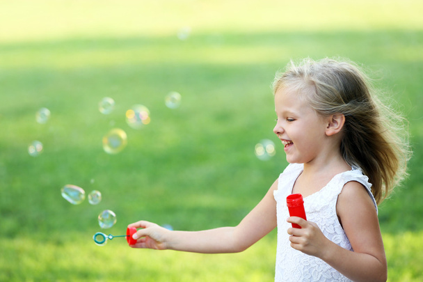 дівчина дме мильні бульбашки
 - Фото, зображення