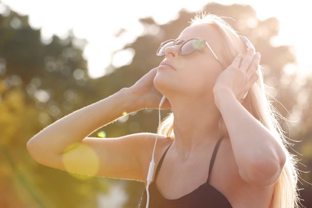 Mujer escuchando música en el parque
 - Foto, imagen
