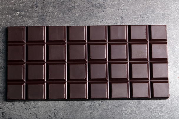 Chocolate bar on dark background - Фото, изображение