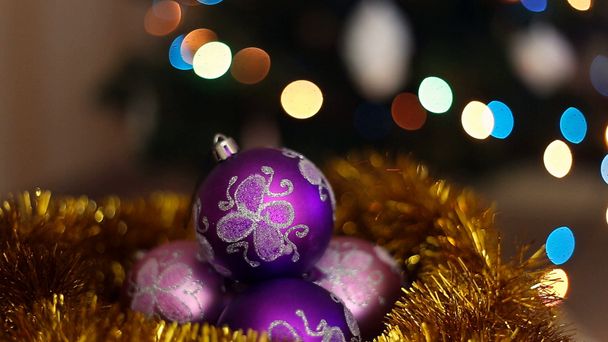 Tři fialové vánoční koule na světlém pozadí bokeh - Záběry, video