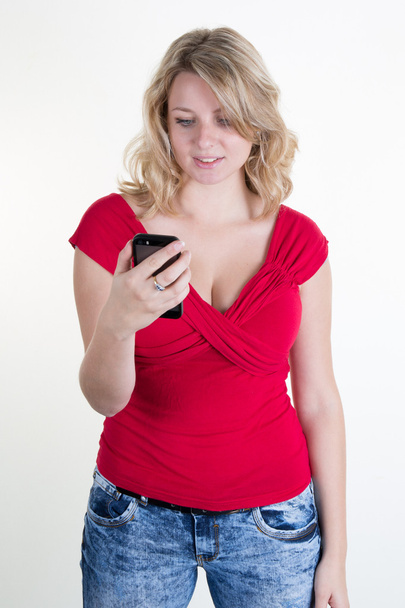chica bonita con un top rojo mirando su teléfono móvil
 - Foto, Imagen