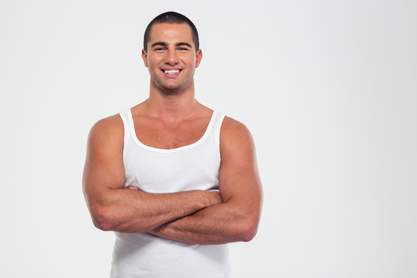 Happy muscular man standing with arms folded - Foto, Bild