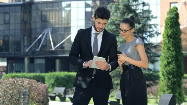 Business couple standing together, work on the tablet and smiling - Footage, Video