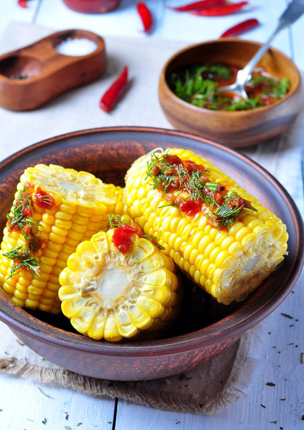 gekookte maïs met hete tomatensaus, kruiden, peper en specerijen - Foto, afbeelding