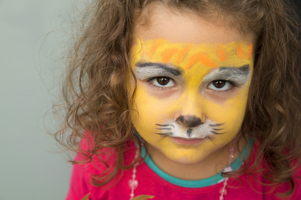 4 years girl with the face painted like a tiger - 写真・画像