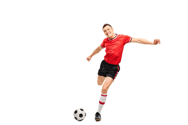 Young football player kicking a ball - Valokuva, kuva