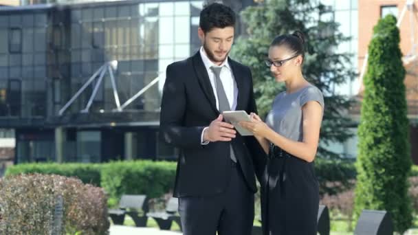 Business couple standing together and work on the tablet - Footage, Video