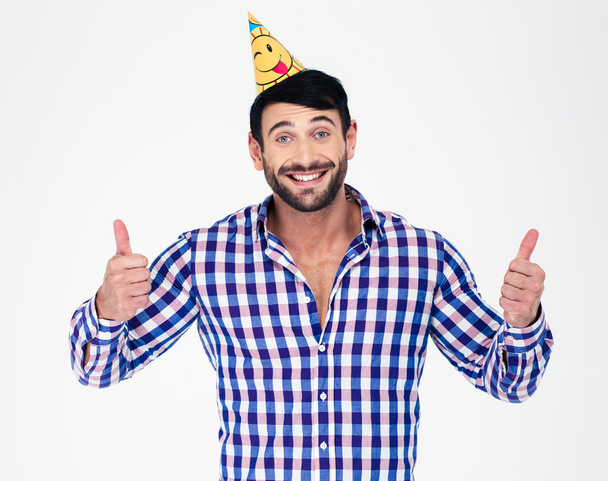 Happy man in party hat showing thumbs up - Foto, immagini