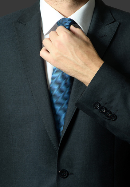 Üzletember igazítja a nyakkendőjét - közelkép lövés  - Fotó, kép