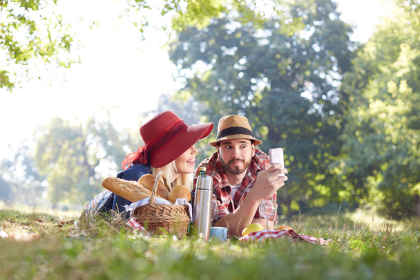 Composite of Couple taking selfie on smartphone on romantic picnic - Φωτογραφία, εικόνα