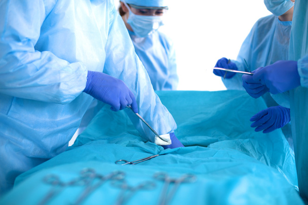 Equipo de cirujanos uniformados realiza la operación a un paciente en la clínica de cirugía cardíaca
 - Foto, Imagen