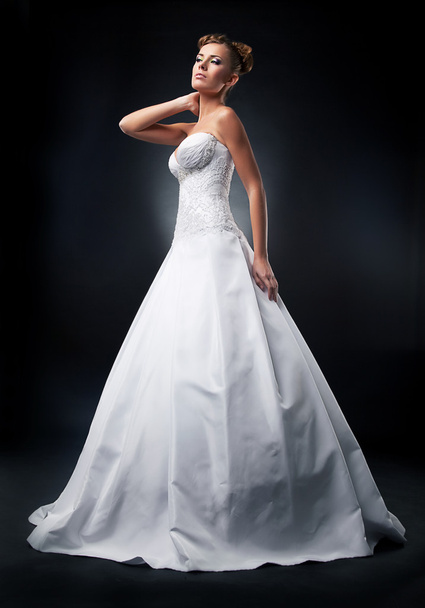 Lovely young fiancee blonde posing in nuptial white dress - Foto, imagen