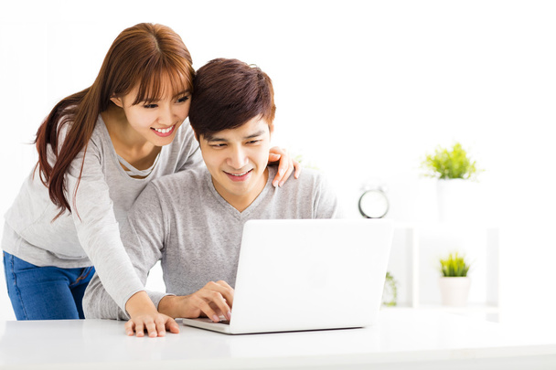 happy young Couple Looking at Laptop In living room - 写真・画像