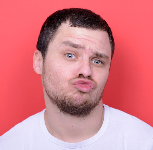Portrait of man with funny face against red background - Photo, Image