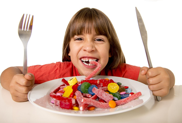 дитина їсть цукерки, як божевільний у зловживанні цукром та здоровій концепції солодкого харчування
 - Фото, зображення
