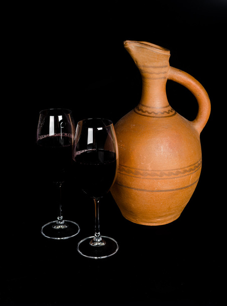 Kerámia korsó bor és egy pohár vörös bor - Fotó, kép