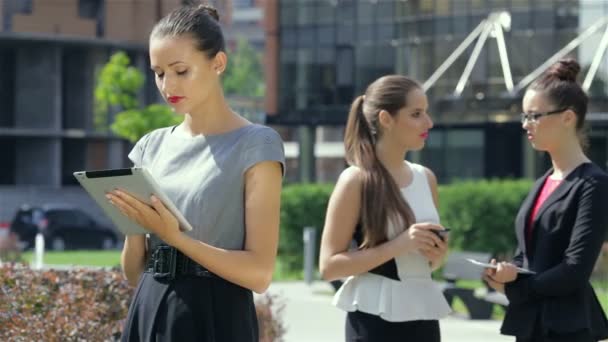 Mujer de negocios que trabaja en una tableta en el fondo de sus socios comerciales
 - Metraje, vídeo