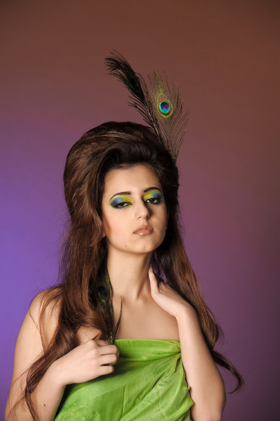 Portarit of beautiful young girl with peacock feather - Foto, imagen