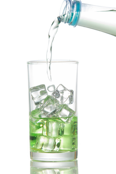 Woda przelewa się do szklanki z kostkami lodu - Zdjęcie, obraz