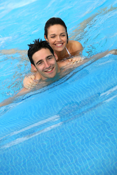 Couple swimming together in pool - Φωτογραφία, εικόνα