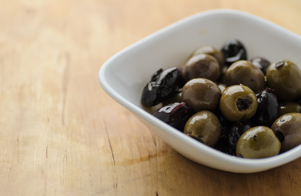 Змішані оливки в білій мисці
 - Фото, зображення