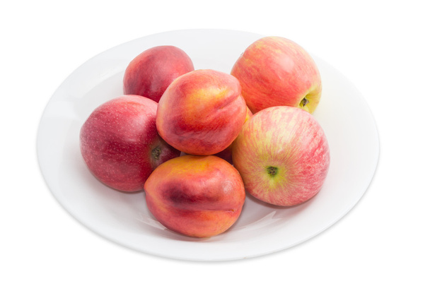 Több piros alma és egy fehér edényt nektarin - Fotó, kép
