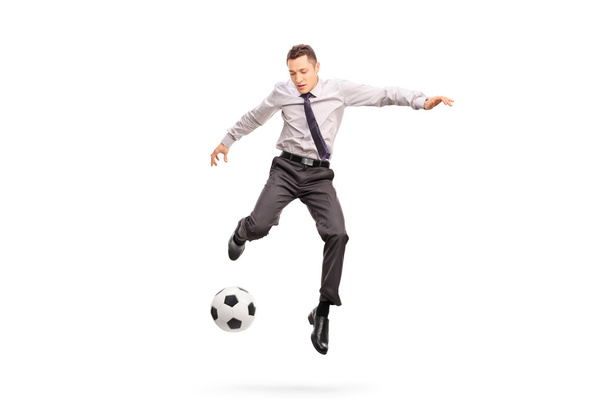 Young businessperson kicking a football - Foto, Imagem