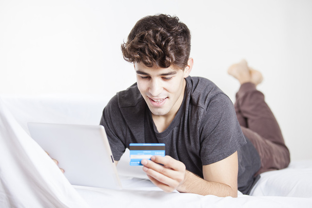 Dorywczo młody człowiek robi zakupy online za pośrednictwem cyfrowego tabletu i karty kredytowej - Zdjęcie, obraz
