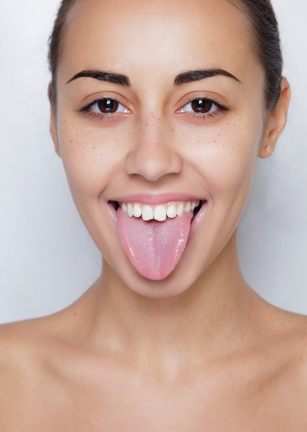 Beautiful woman sticking out her tongue and showing young piercing - Φωτογραφία, εικόνα