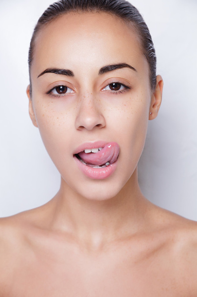 Beautiful woman sticking out her tongue and showing young piercing - Photo, Image