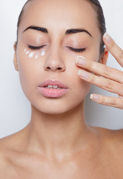 beautiful model applying cosmetic cream treatment on her face white - Fotografie, Obrázek