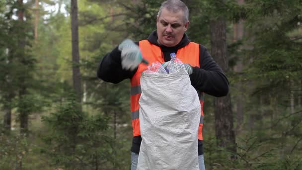 Homem com saco de garrafas de plástico na floresta
 - Filmagem, Vídeo
