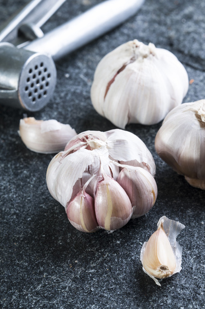 Garlic press and garlic bulbs - Foto, imagen