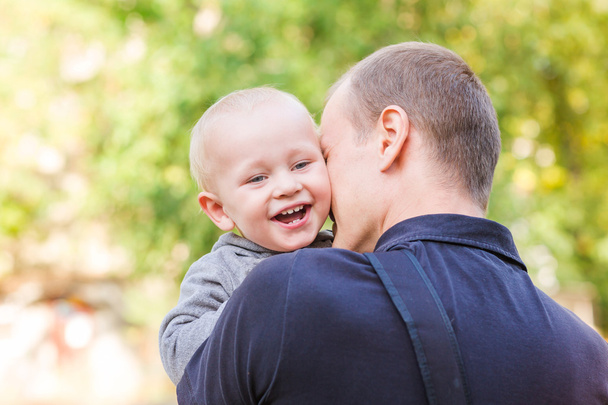 Happy father and his son outdoors. Child hugging daddy. - Photo, Image
