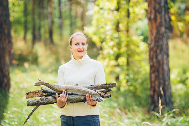 woman gathering wood for a fire - Foto, afbeelding
