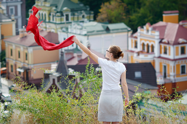 woman standing on the hill and waving a red scarf - Foto, Bild