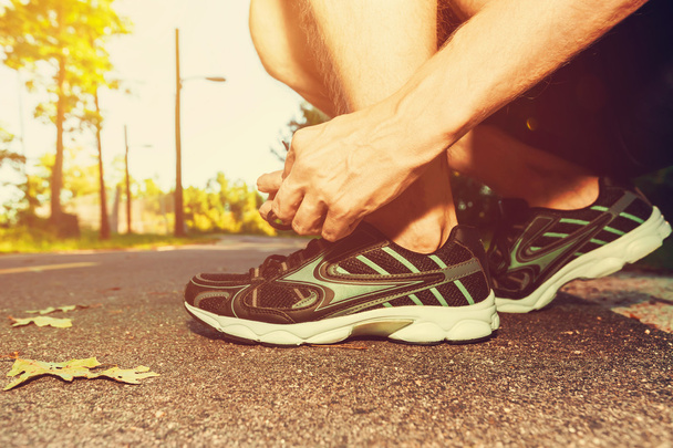 Male jogger tying his running shoes - Photo, image
