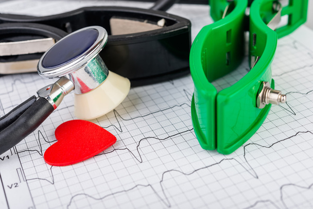 EKG-elektrodit sydänsähkökäyrän taustalla
 - Valokuva, kuva