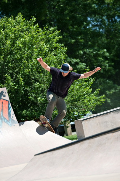 Skateboarder Riding Up a Concrete Skate Ramp - 写真・画像