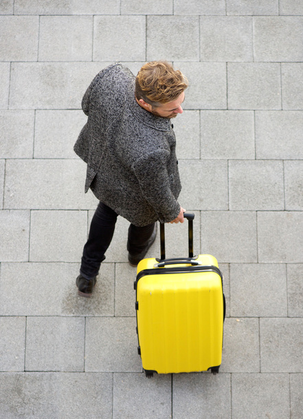 Férfi séta a sárga bőrönd utazótáska - Fotó, kép