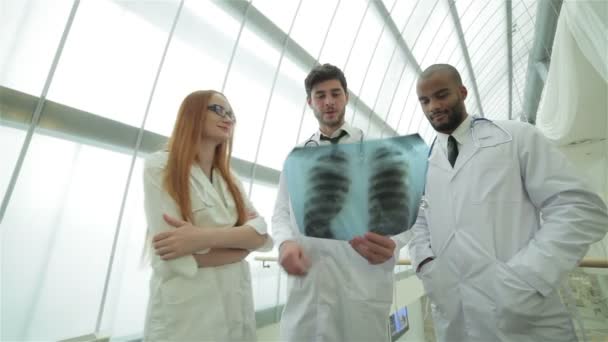 Tres médicos confiados examinando radiografía de los pulmones
 - Metraje, vídeo