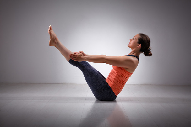 Frau praktiziert Yoga asana paripurna navasana - Foto, Bild