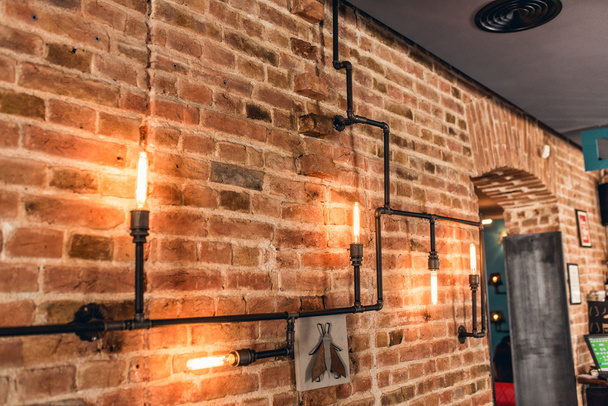 restaurant rustic walls, vintage interior design lamps, metal pipes and light bulbs - Фото, изображение