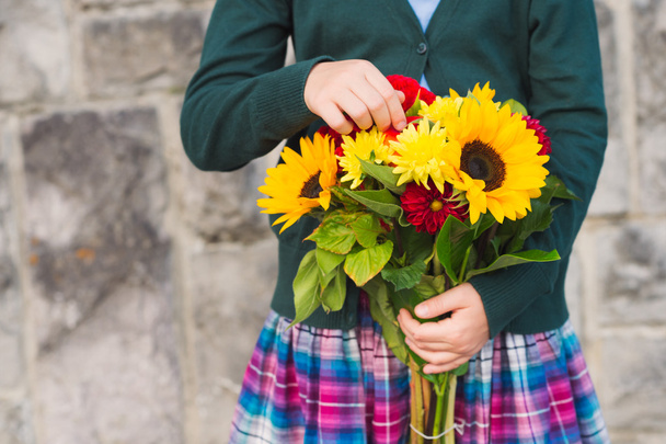 Belo buquê de flores brilhantes e coloridas segurando as mãos da criança
 - Foto, Imagem