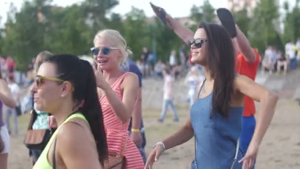 ST. PETERSBURG, RUSSIA - JULY 18, 2015: VK FEST. Girls in shorts and dresses and boys dancing on summer beach disco music dj - Felvétel, videó