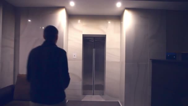 az ember este illeszkedik, és megnyitja a lift, a szálloda épületében - Felvétel, videó